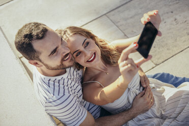 Smiling couple taking selfie with smartphone - JSMF00641