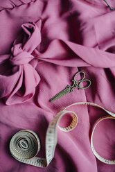 High angle view of scissors and tape measure on dress - CAVF57829