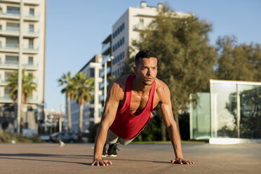 Muscular man doing pushups in the city - MAUF01757
