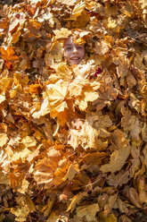 Lächelndes Mädchen, bedeckt mit Herbstblättern - SARF03998