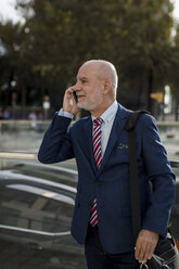 Senior businessman talking on cell phone in the city - MAUF01785