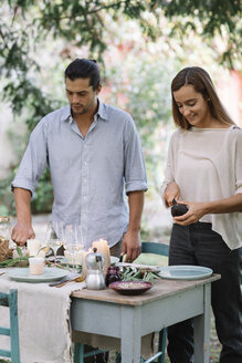 Couple preparing a romantic candlelight meal outdoors - ALBF00711