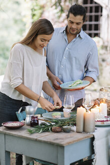 Paar bei der Zubereitung einer romantischen Mahlzeit bei Kerzenlicht im Freien - ALBF00715