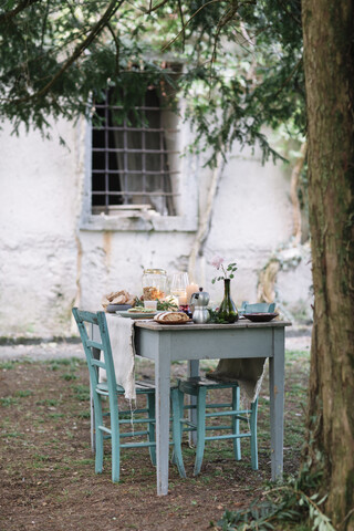 Gedeckter Gartentisch mit Kerzen neben einer Hütte, lizenzfreies Stockfoto