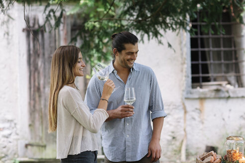 Couple with wine glasses having a romantic candelight meal next to a cottage - ALBF00724