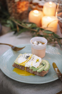 Bread with avocado and dessert on garden table with candles - ALBF00733