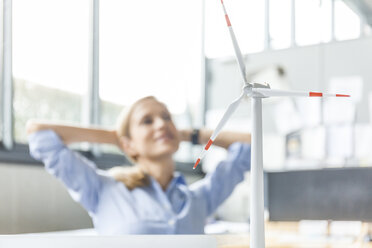 Windkraftanlagenmodell und Frau im Hintergrund im Büro - TCF06018