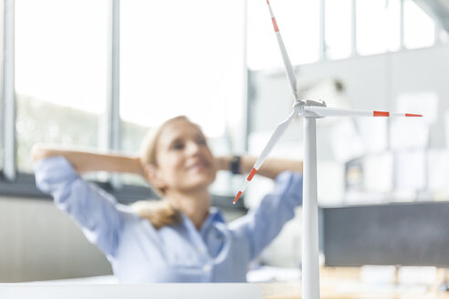 Windkraftanlagenmodell und Frau im Hintergrund im Büro - TCF06018