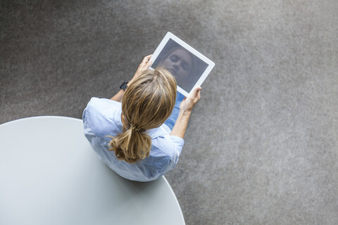 Top view of woman using tablet at table stock photo