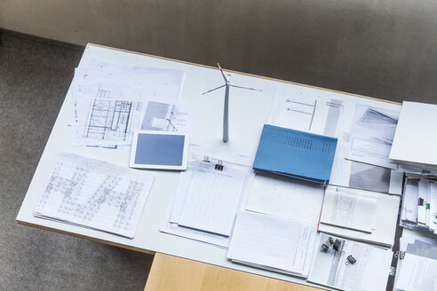 Modell einer Windkraftanlage, Baupläne und Tablet auf einem Tisch im Büro - TCF06035