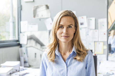 Porträt einer selbstbewussten Frau im Büro, lizenzfreies Stockfoto