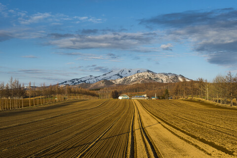 Hokkaido, Kleiner Bauernhof vor einem schneebedeckten Berg in der Nähe des Shiretoko-Nationalparks, lizenzfreies Stockfoto