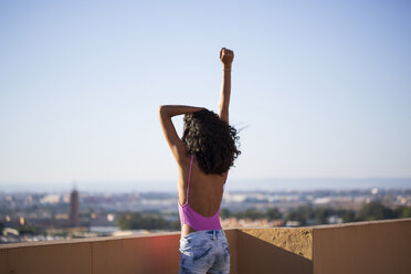 Portrait of teenage girl, raising arm, rear view - ERRF00258