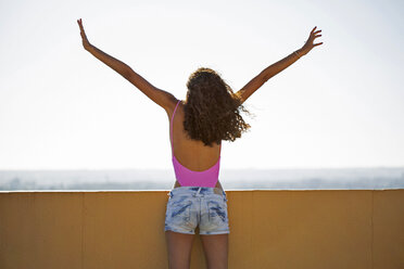 Portrait of teenage girl, raising arms, rear view - ERRF00260