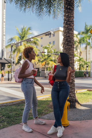 USA, Florida, Miami Beach, two happy female friends having a soft drink in the city stock photo