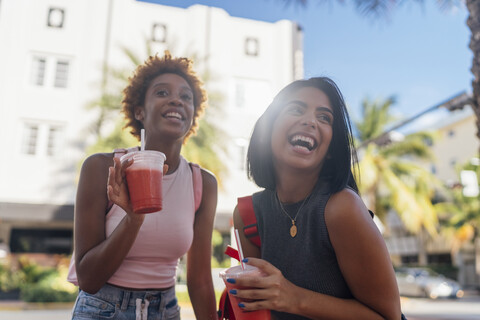 USA, Florida, Miami Beach, two happy female friends having a soft drink in the city stock photo