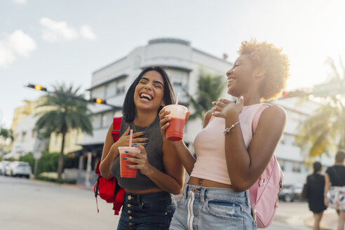 USA, Florida, Miami Beach, zwei glückliche Freundinnen bei einem Softdrink in der Stadt - BOYF01178