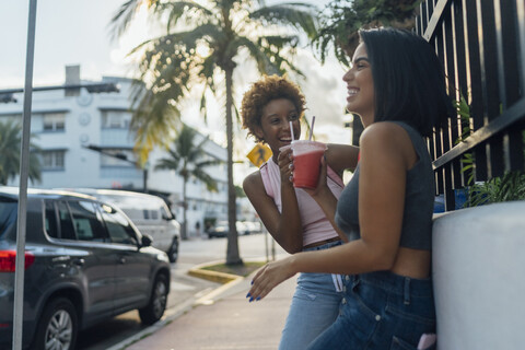 USA, Florida, Miami Beach, two happy female friends having a soft drink in the city stock photo