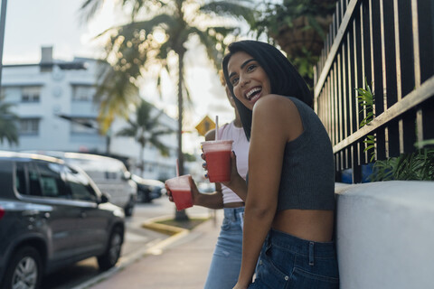 USA, Florida, Miami Beach, two happy female friends having a soft drink in the city stock photo