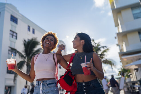 USA, Florida, Miami Beach, zwei glückliche Freundinnen bei einem Softdrink in der Stadt - BOYF01185