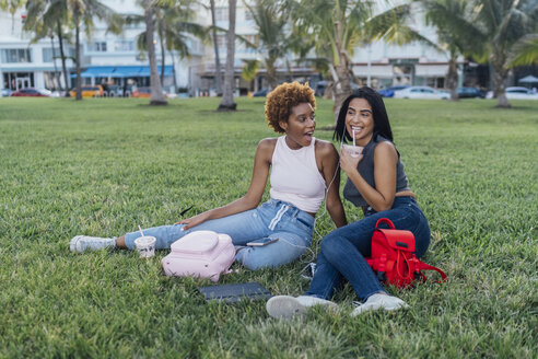 Zwei glückliche Freundinnen entspannen sich in einem Park - BOYF01188
