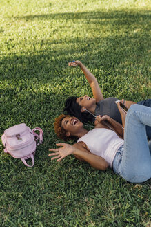 Zwei sorglose Freundinnen entspannen sich im Park und hören Musik - BOYF01194