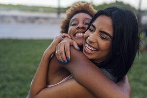 Porträt von zwei glücklichen Freundinnen, die sich in einem Park umarmen - BOYF01217