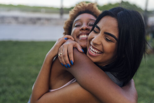 Portrait of two happy female friends hugging in a park - BOYF01217