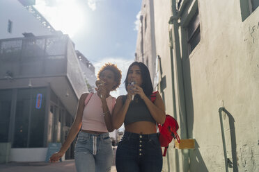 USA, Florida, Miami Beach, two female friends eating ice cream cones in the city - BOYF01218