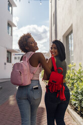 USA, Florida, Miami Beach, rear view of two happy female friends walking in the city - BOYF01233