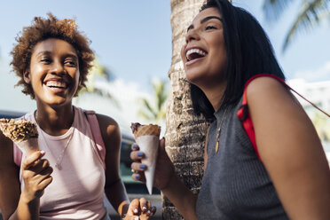 Two happy female friends with ice cream cones at a palm tree - BOYF01235