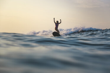 Indonesien, Bali, Batubolong Strand, Schwangere Frau beim Surfen - KNTF02455