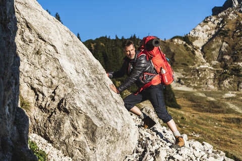 Mann beim Bergwandern in felsigem Terrain, lizenzfreies Stockfoto