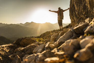 Hiking man standing in he mountains, cheering - UUF16014