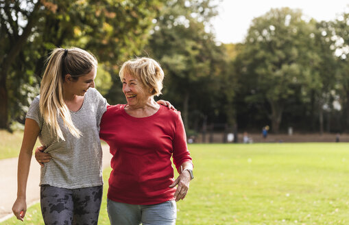 Granddaughter and grandmother having fun, jogging together in the park - UUF16051