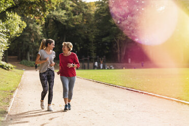Granddaughter and grandmother having fun, jogging together in the park - UUF16057