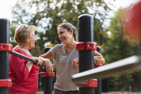 Grandmother and granddaughter training on bars in a park stock photo