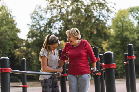 Grandmother and granddaughter training on bars in a park stock photo