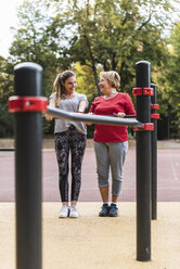 Grandmother and granddaughter training on bars in a park - UUF16069