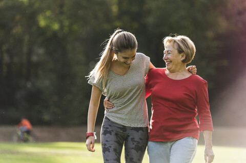 Enkelin und Großmutter haben Spaß, joggen zusammen im Park, lizenzfreies Stockfoto