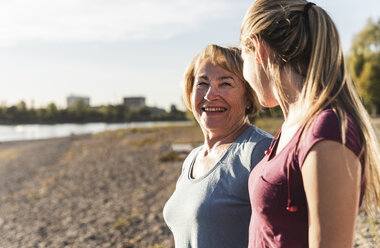 Fit grandmother and grandmother enjoying the sun at the river - UUF16092