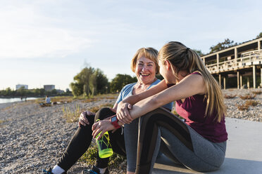 Grandmother and granddaughter taking a break after exercising at the river - UUF16104