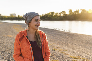 Portrait of a sportive young woman at the river, weraing a beanie hat - UUF16119