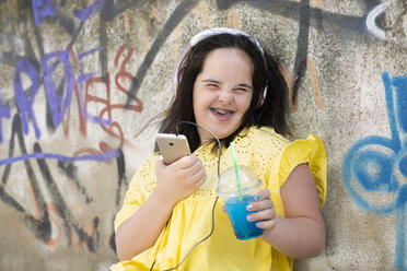 Teenager mit Down-Syndrom benutzt Smartphone, hält Plastikbecher - ERRF00271