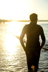 Silhouette eines Mannes, Spaziergang am Strand bei Sonnenuntergang, Rückansicht - PUF01342