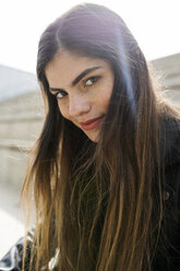 Porträt einer selbstbewussten jungen Frau mit langen braunen Haaren im Freien - VABF01948