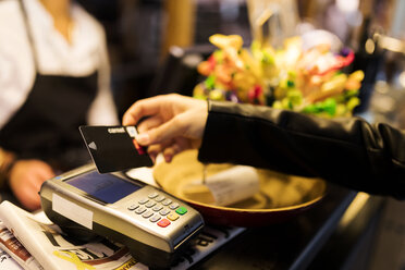 Close-up of woman paying with credit card at the counter - VABF01976