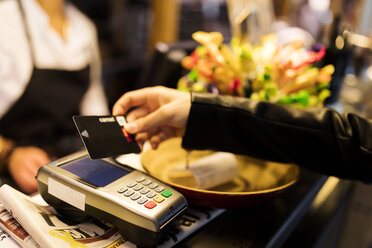 Nahaufnahme einer Frau, die am Schalter mit Kreditkarte bezahlt - VABF01976