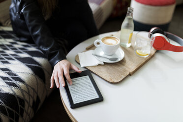 Nahaufnahme einer jungen Frau in einem Café, die ein E-Book benutzt - VABF01979