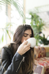 Porträt einer jungen Frau in einem Café, die Kaffee trinkt - VABF01983